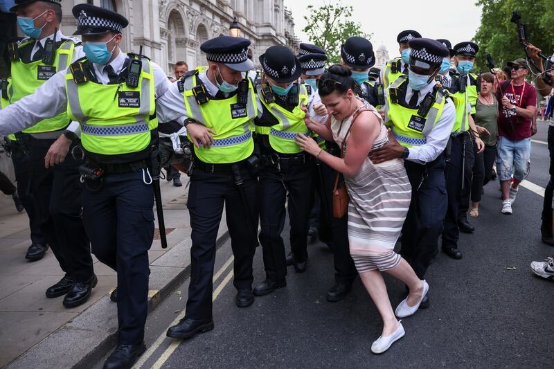 A woman tires to stop police from arresting a demonstrator during an anti-lockdown and anti-vaccine protest in London, UK. Reuters