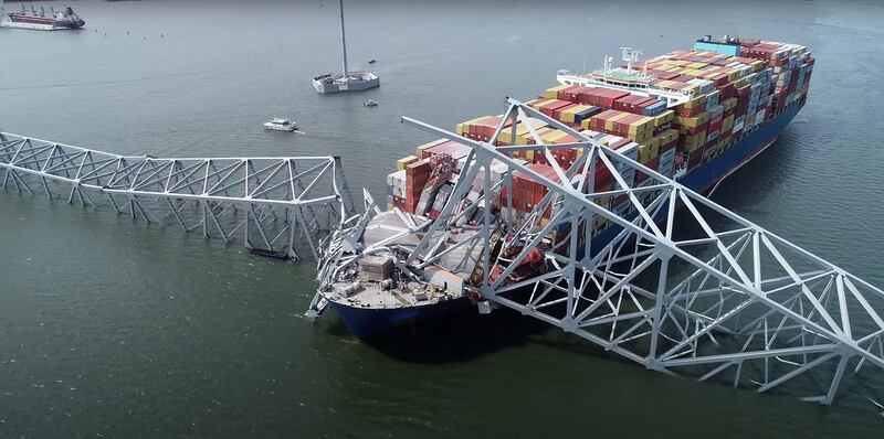 A handout screengrab shows part of the steel frame of the Francis Scott Key Bridge sitting on top of the container ship Dali after the bridge collapsed in Baltimore, Maryland. AFP