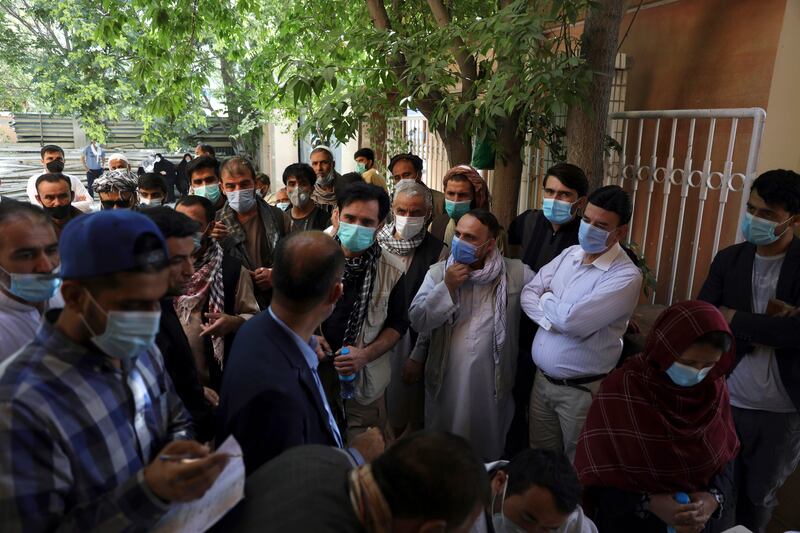 Residents, wearing face masks to help curb the spread of the coronavirus, line up to receive a Covid-19 vaccine in Kabul amid a rise in cases in  Afghanistan. AP