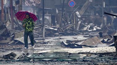 A man walks past the debris in an area hit by a fire, following earthquakes in Wajima, Ishikawa prefecture, Japan Wednesday, Jan.  3, 2024.  A series of powerful earthquakes that hit western Japan left multiple people dead Wednesday, as rescue workers fought to save those feared trapped under the rubble of collapsed buildings. (Kyodo News via AP)