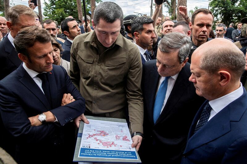 Ukrainian Minister for Communities and Territories Development Oleksiy Chernyshov shows a wartime map to French President Emmanuel Macron, German Chancellor Olaf Scholz, Italian Prime Minister Mario Draghi and Romanian President Klaus Iohannis (partially obscured) during their visit, as Russia's attack on Ukraine continues, in Irpin, near Kyiv, Ukraine June 16, 2022.   REUTERS / Viacheslav Ratynskyi TPX IMAGES OF THE DAY