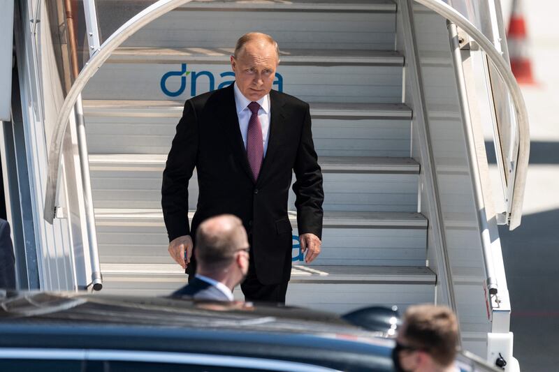 Vladimir Putin steps down the stairs from his plane in Geneva Airport. AFP