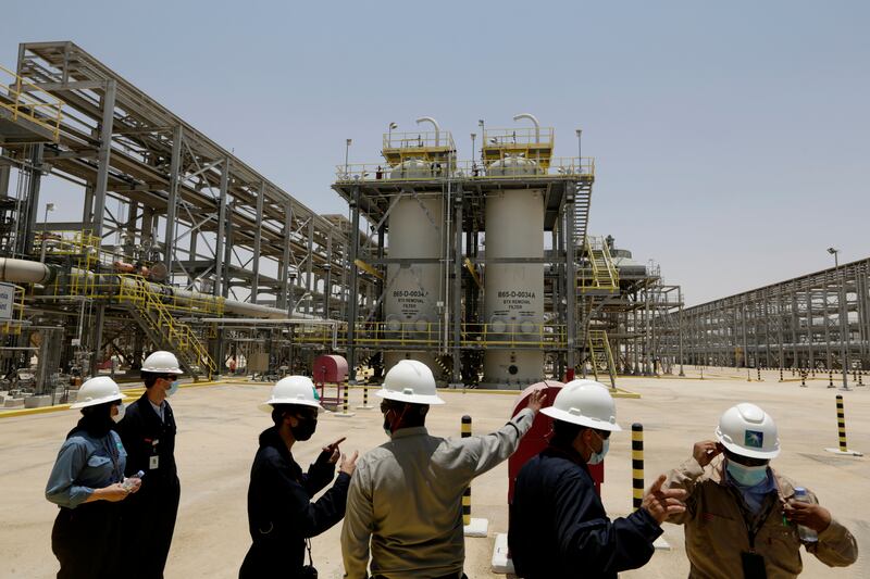 FILE - In this June 28, 2021, file photo, Saudi Aramco engineers and journalists look at the Hawiyah Natural Gas Liquids Recovery Plant, which is designed to process 4. 0 billion standard cubic feet per day of sweet gas, a natural gas that does not contain significant amounts of hydrogen sulfide, in Hawiyah, in the Eastern Province of Saudi Arabia.  Aramco, announced Sunday, Aug.  8, 2021, a net income of around $47 billion for the first half of the year, double what it earned in the same period last year when the coronavirus grounded travel and pummeled global demand for oil.  (AP Photo / Amr Nabil, File)