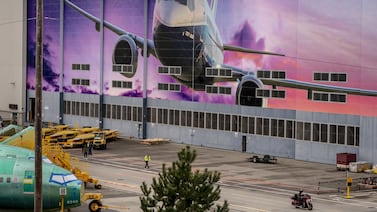 A worker walks under a mural of a Boeing Co.  737-800 airplane outside the company's manufacturing facility in Renton, Washington, US. Bloomberg