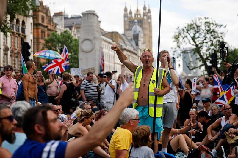 Demonstrators stage a sit-down protest outside Downing Street against government lockdown restrictions, 5G and Covid-19 vaccinations in central London. Britain has delayed the full lifting of coronavirus restrictions in England owing to a surge of infections caused by the Delta variant. AFP