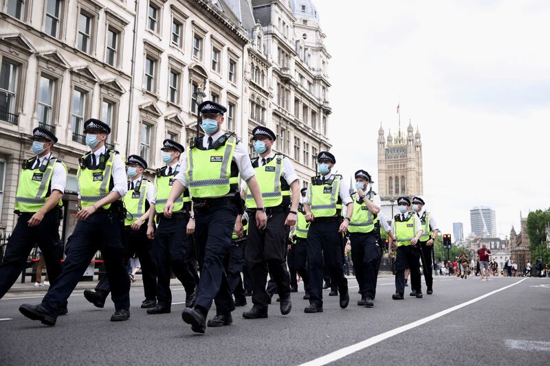 Police officers walk down Whitehall during an anti-lockdown and anti-vaccine protest in London. Reuters
