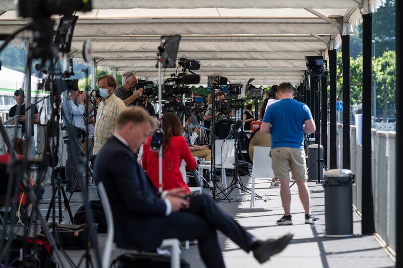 Journalists, camera operators and photographers work in the media tent across the street from where the summit between the leaders will take place. AP Photo