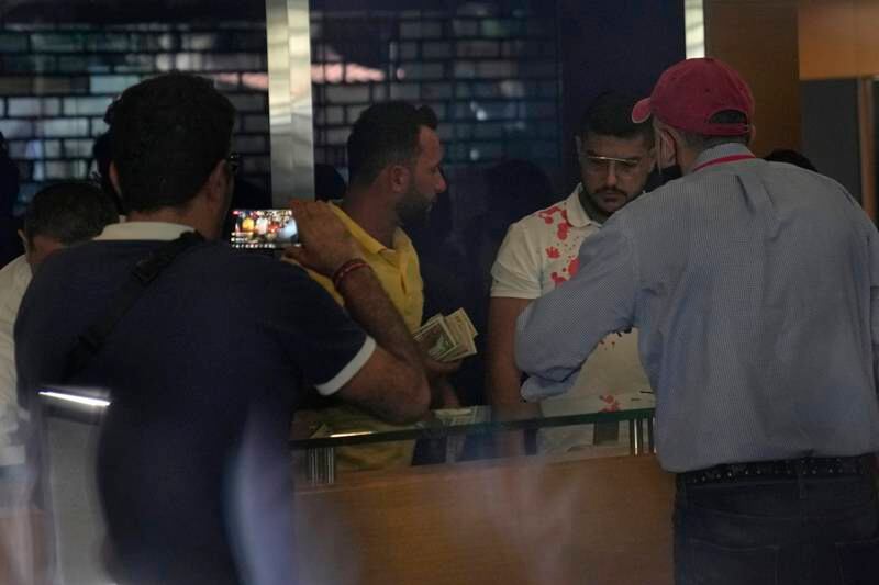 Lebanese depositors inside a Blom Bank branch in Beirut. A group of customers, at least one of whom was armed, took hostages in the bank, demanding access to their savings. They were reportedly able to withdraw $20,000 from an account of one of the depositors before they left. EPA