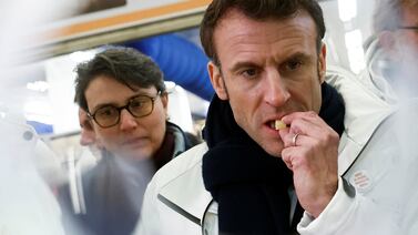 French President Emmanuel Macron tastes cheese as he visits the Rungis International wholesale market in Rungis, south of Paris, Tuesday Feb 21, 2023.  French President Emmanuel Macron visits Europe's biggest food marketplace before dawn, and tries to sell his retirement reform that would raise the minimum retirement age for a full state pension from 62 to 64.  (Benoit Tessier, Pool via AP)