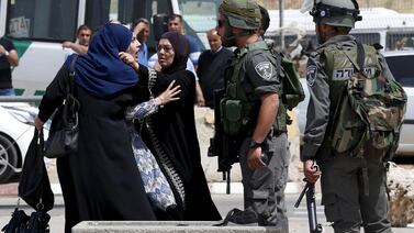A Palestinian woman argues with an Israeli border policeman near the scene where two Palestinians where shot dead by Israeli forces near Qalandia checkpoint in the West Bank. Ammar Awad / Reuters