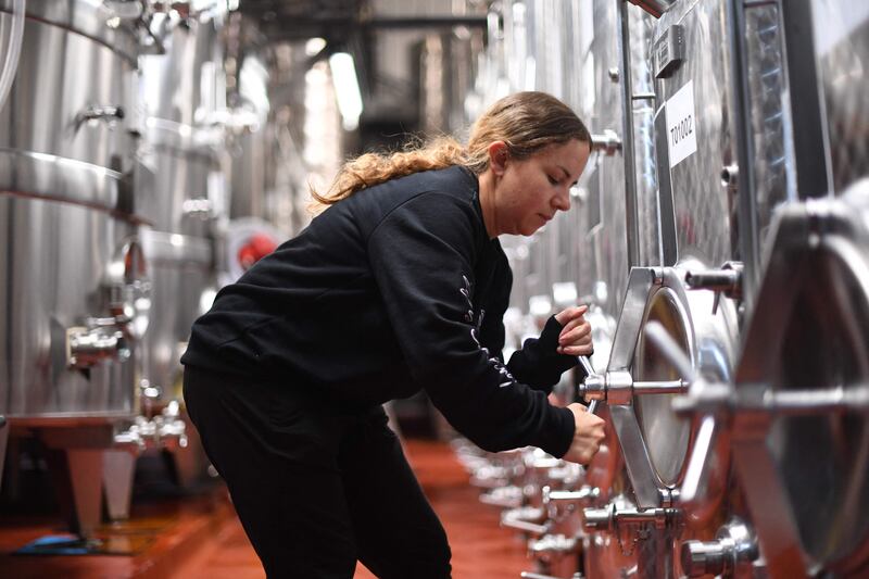 A worker inspects wine vats at Ridgeview Estate's winery near Burgess Hill, southern England, on June 22, 2021.  - Problems have shaken the lives of many businesses across the country since the UK's effective exit from the single market in early January, without it being yet possible to know whether they will be temporary or sustainable.  "We had no recruitment problem, it's only since this year that we have seen labour shortages.  It's really complicated with the pandemic, the travel restrictions, to see where the pressures are coming but we think that Brexit made people stay at home because we did not make it easy for them to come", Tamara Roberts, CEO of Ridgeview Estate Winery told AFP.  (Photo by DANIEL LEAL-OLIVAS  /  AFP)  /  TO GO WITH AFP STORY BY Veronique DUPONT