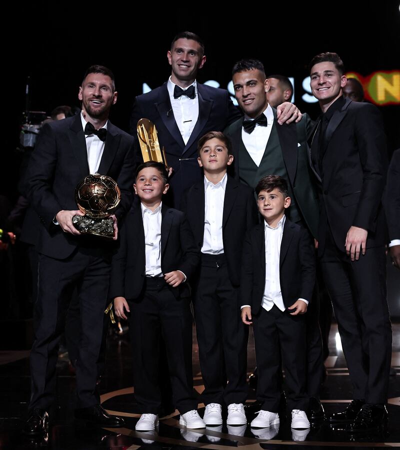 Inter Miami CF's Argentine forward Lionel Messi (L) poses with his trophy and his children (bottom), next to Aston Villa's Argentine goalkeeper Emiliano Martinez (Top 2L), Inter Milan's Argentine forward Lautaro Martinez (2R) and Manchester City's Argentine forward Julian Alvarez (R) during the 2023 Ballon d'Or France Football award ceremony at the Theatre du Chatelet in Paris on October 30, 2023.  (Photo by FRANCK FIFE  /  AFP)