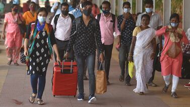  Indian passengers walk with their belongings as they arrive by a train at Chennai Central railway station in Chennai, India, 23 June 2021.  Tamil Nadu state government eases ongoing lockdown as it resumes bus services in four districts of the state with lower Covid-19 cases.   EPA / IDREES MOHAMMED