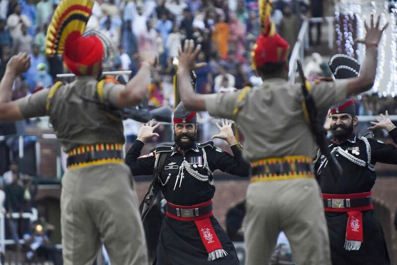 This picture taken on August 15, 2022, shows Indian Border Security Force (BSF) soldiers and Pakistani Rangers (in black) taking part in the Beating the Retreat ceremony during India's 75th Independence Day celebrations at the India-Pakistan Wagah border post, about 35km from Amritsar.  (Photo by Narinder NANU  /  AFP)