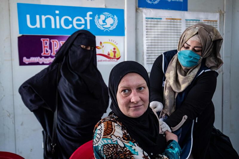 A woman receives a a shot of a Covid-19 vaccine in the Kurdish-run Al Hol camp in Syria. AFP
