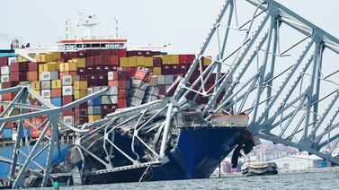 A cargo ship is stuck under the part of the structure of the Francis Scott Key Bridge after the ship hit the bridge on March 26, in Baltimore.  AP