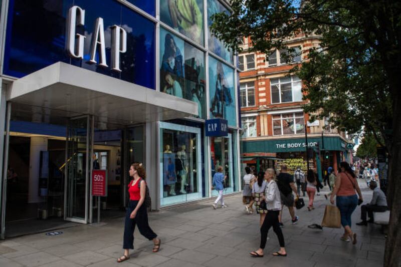 Shoppers pass the GAP store on Oxford Street in London. Consumers scaled back their shopping in May as they chose to eat out instead. Getty Images