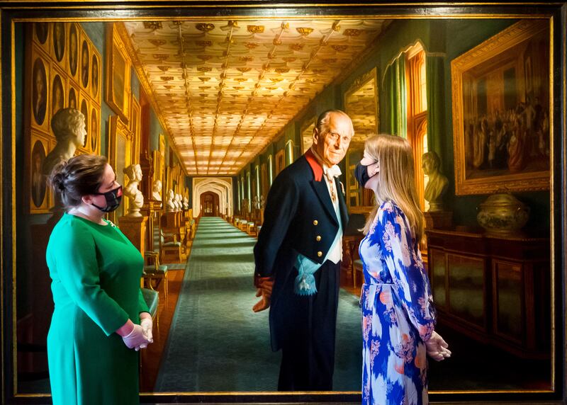 Members of staff from the Royal Collection Trust look at a portrait of the Duke of Edinburgh by Ralph Heimans during a photocall preview of the 'Prince Philip: A Celebration' exhibition at Windsor Castle. EPA