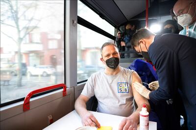 BERLIN, GERMANY - MARCH 10: German Federal Health Minister Karl Lauterbach vaccinates a person with a dose of coronavirus disease (COVID-19) vaccine in the #ImpfenHilft tour bus at the project's launch on March 10, 2022 in Berlin, Germany. #ImpfenHilft, which translates to: "vaccination helps" is a nationwide effort to reach to people still skeptical of getting inoculated against Covid-19. (Photo by Michele Tantussi / Getty Images)