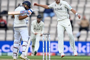 New Zealand's Tim Southee (R) celebrates dismissing India's Rohit Sharma (L) for 30 runs on the fifth day of the ICC World Test Championship Final between New Zealand and India at the Ageas Bowl in Southampton, southwest England on June 22, 2021.  (Photo by Glyn KIRK  /  AFP)  /  RESTRICTED TO EDITORIAL USE