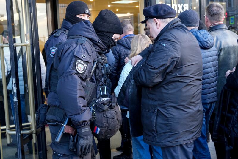 Riot police check the bags of spectators as they guard an area at the Oktyabrsky Concert Hall prior to the concert of the rock group 'Picnic' and the symphony orchestra 'Tavrichesky' in St.  Petersburg, Russia, Wednesday, on March 27.  AP