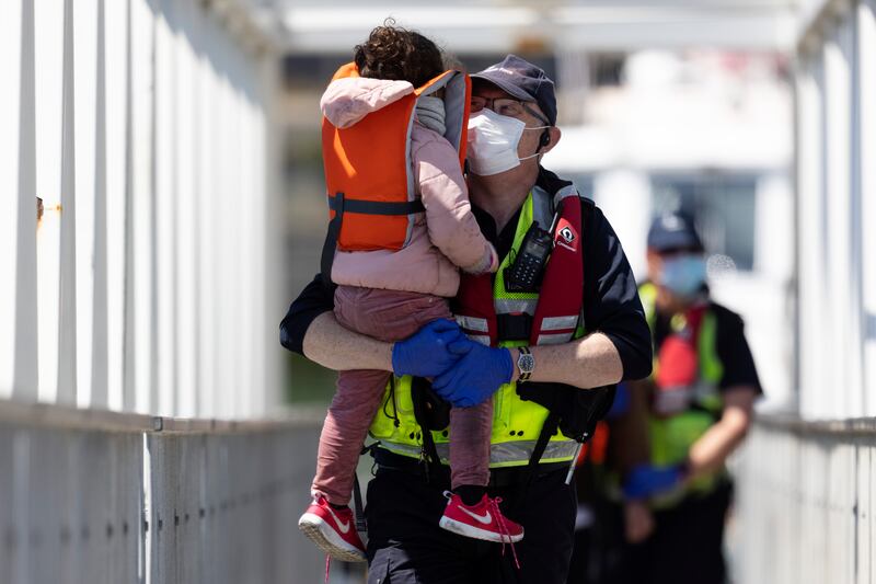 Border Force official holds an unaccompanied child migrant who arrived in Kent in early June. Getty