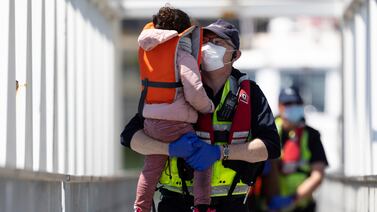 Border Force official holds an unaccompanied child migrant who arrived in Kent in early June. Getty