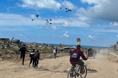 Palestinians rush towards the beach to collect aid airdropped by an airplane, on March 25. Reuters