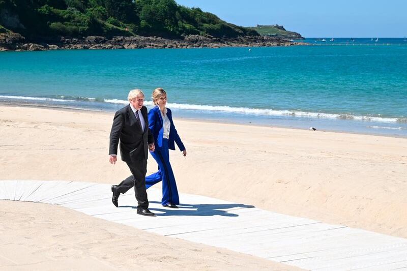 Britain's Prime Minister Boris Johnson and his wife Carrie Johnson make their way to greet guests at an official welcome at the G7 summit in Carbis Bay, Cornwall, England, on Saturday, June 12, 2021. AP