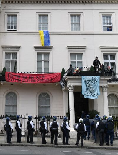 LONDON, ENGLAND - MARCH 14: (EDITORS NOTE: image contains profanity.) Police officers in riot gear arrive as protesters occupy a building reported to belong to Russian oligarch Oleg Deripsaka on March 14, 2022 in London, England. Overnight, protesters broke into 5 Belgrave Square, which reportedly belongs to the family of Oleg Deripaska, a wealthy Russian recently sanctioned by the UK government as part of its response to Russia's invasion of Ukraine. (Photo by Chris J Ratcliffe / Getty Images)