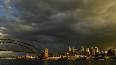 A storm cloud passes over the Sydney Harbour Bridge in Sydney, Australia, 15 July 2021.  New South Wales has recorded 65 new locally transmitted coronavirus cases overnight, 28 of which were infectious during their time in the community.   EPA / MICK TSIKAS AUSTRALIA AND NEW ZEALAND OUT