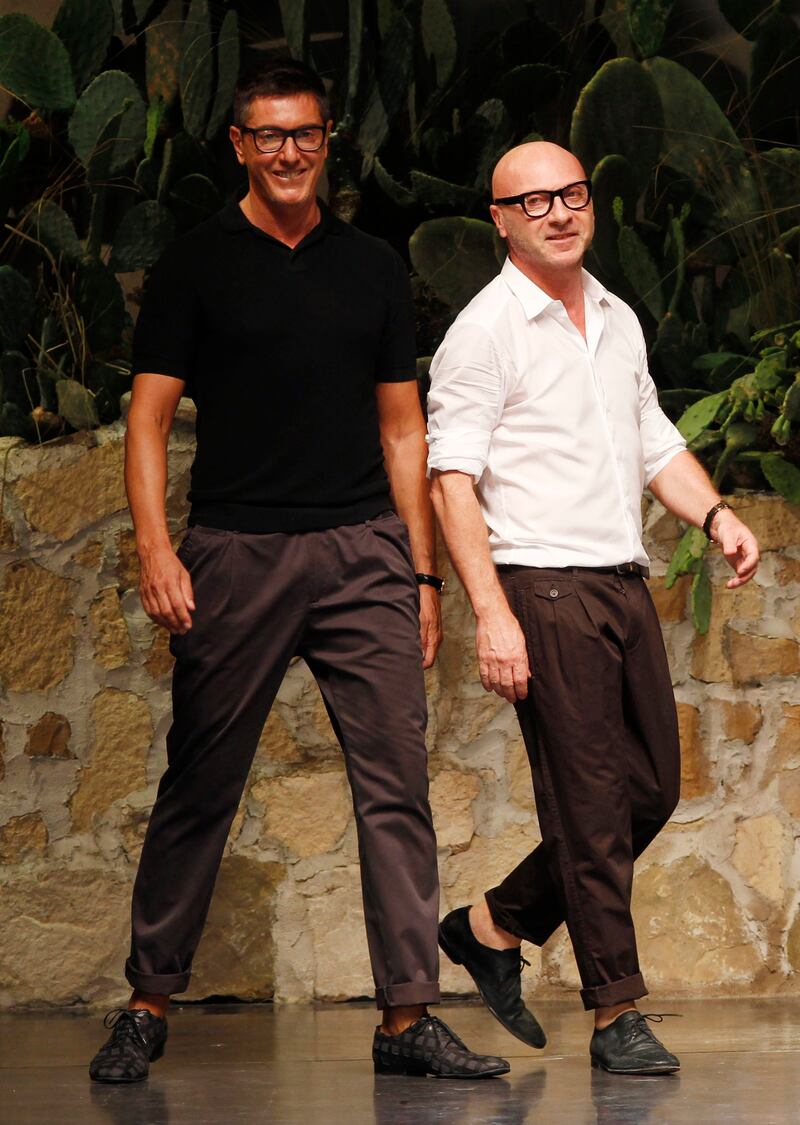 Italian fashion designers Stefano Gabbana, left, and Domenico Dolce take the catwalk after presenting their Dolce & Gabbana men's fashion collection in Milan, Italy. AP Photo