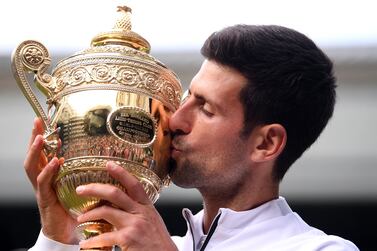 Serbia's Novak Djokovic kisses the winner's trophy after beating Switzerland's Roger Federer during their men's singles final on day thirteen of the 2019 Wimbledon Championships at The All England Lawn Tennis Club in Wimbledon, southwest London, on July 14, 2019.  AFP