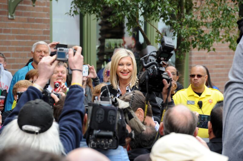 A handout photo made available by the Las Vegas News Bureau shows Olivia Newton-John (C) arriving at the Flamingo in Las Vegas, Nevada, USA, 02 April 2014 (issued 09 August 2022).  Olivia Newton-John died from cancer at the age of 73 at her home in Southern California on 08 August 2022.   EPA / BRIAN JONES  /  LAS VEGAS NEWS BUREAU  /  HANDOUT Mandatory credit: EPA via Las Vegas News Bureau /  Brian Jones HANDOUT EDITORIAL USE ONLY / NO SALES